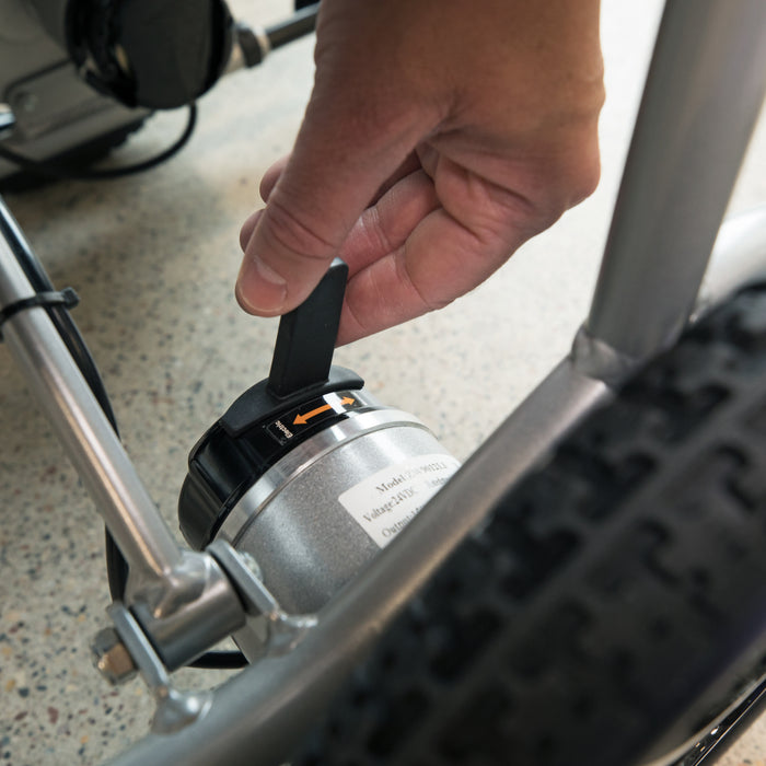 Image of hand on switch that engages the motor so that the Journey Air Electric Wheel chair can either be in free wheel state or be driven by motor